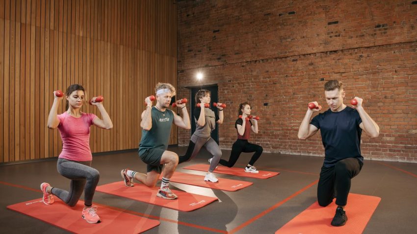 Indoor group workout session with dumbbells focusing on strength and fitness.